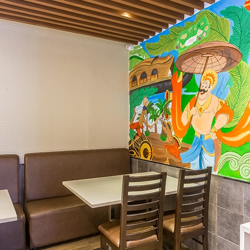 Cozy seating with colorful mural art, wooden accents, and modern dining tables for a lively vibe.