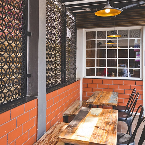 Cozy café with rustic wooden tables, brick walls, and industrial lighting for a warm vibe.